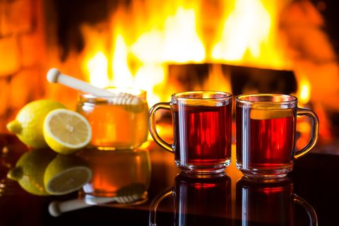 cups of tea, lemons, honey, fire burning in background