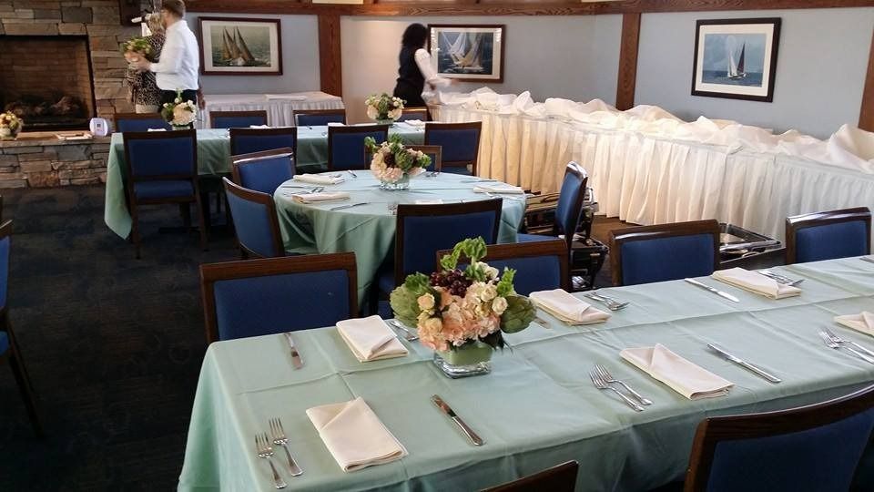 Set dining room with teal tablecloths, blue chairs, and white buffet tables along the wall