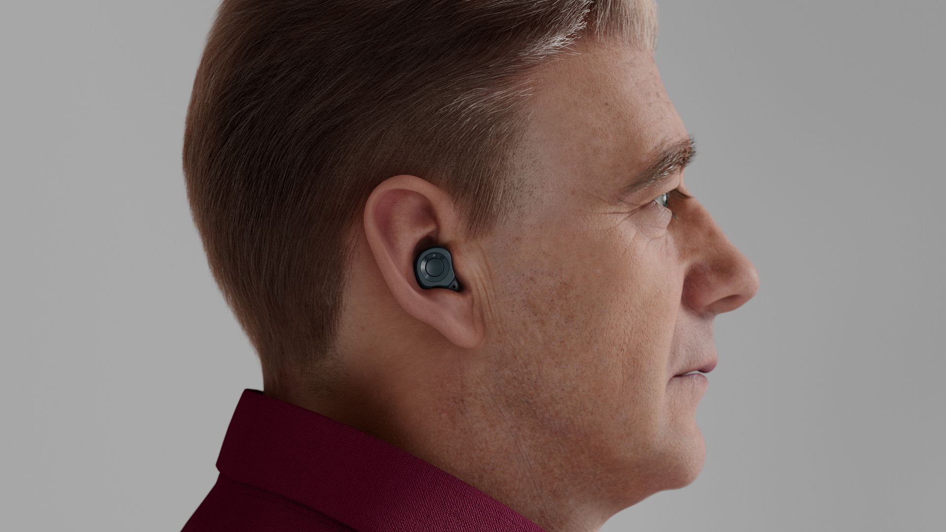 Close-up of a person's ear with a beige, in-the-ear hearing aid. Blonde hair frames the ear.