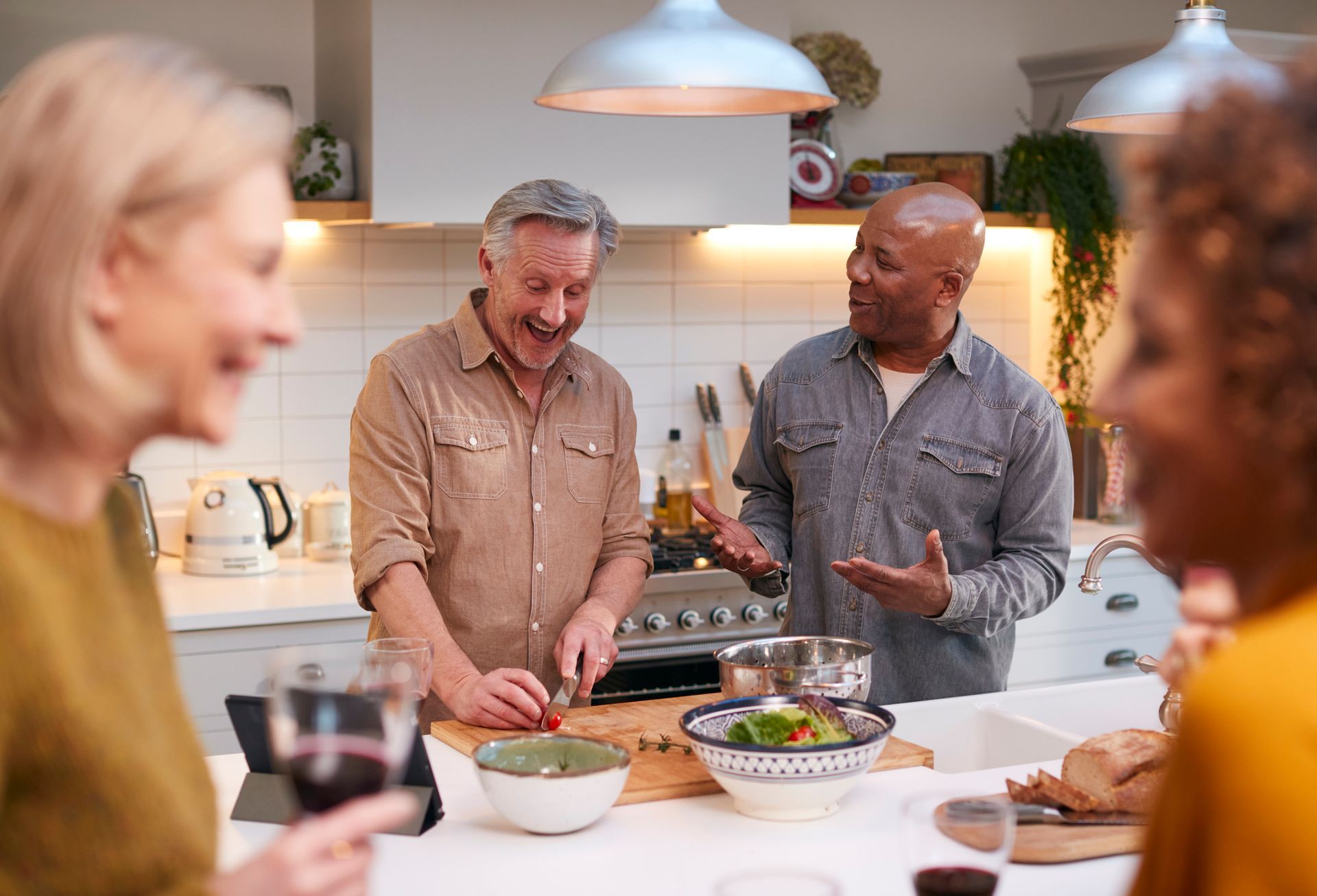Man and woman embracing in a kitchen, both smiling and laughing.