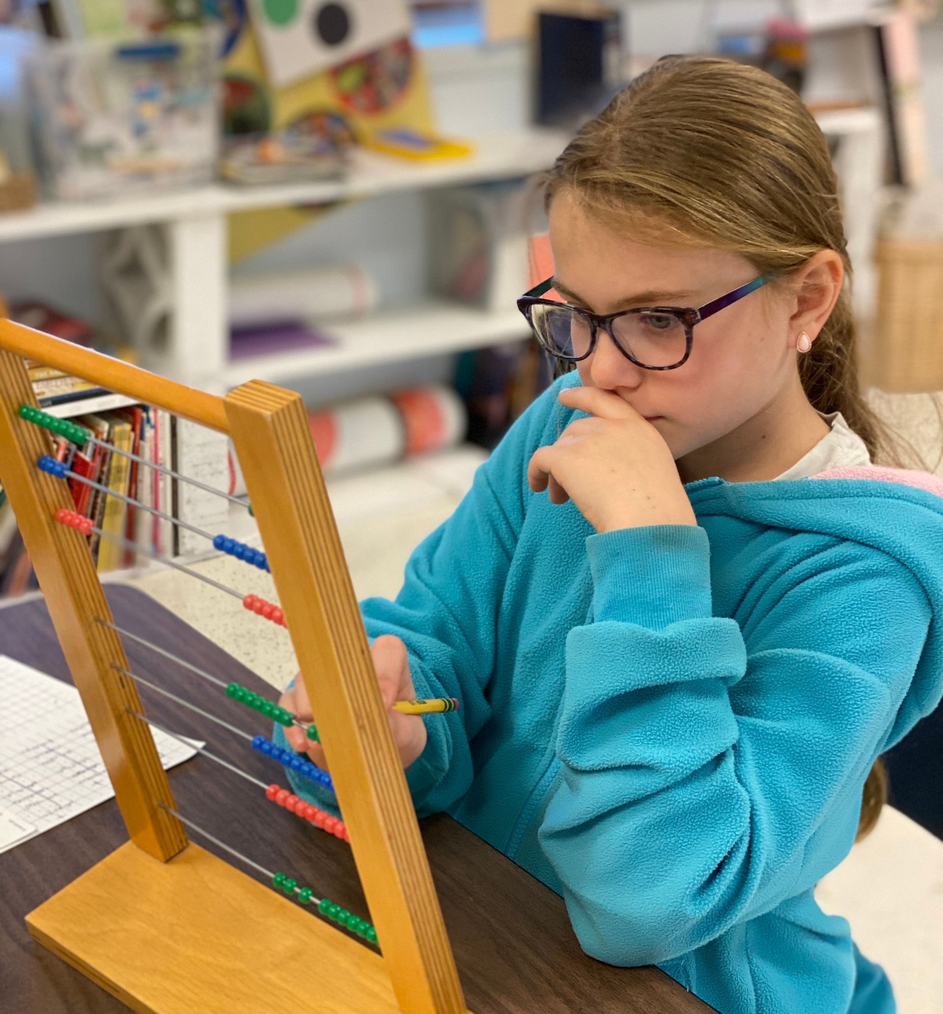 Montessori child working with an abacus