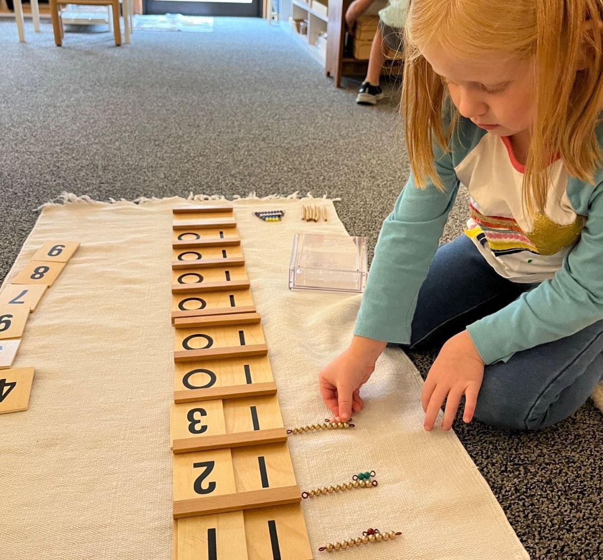 Montessori child working with the golden beads materials 