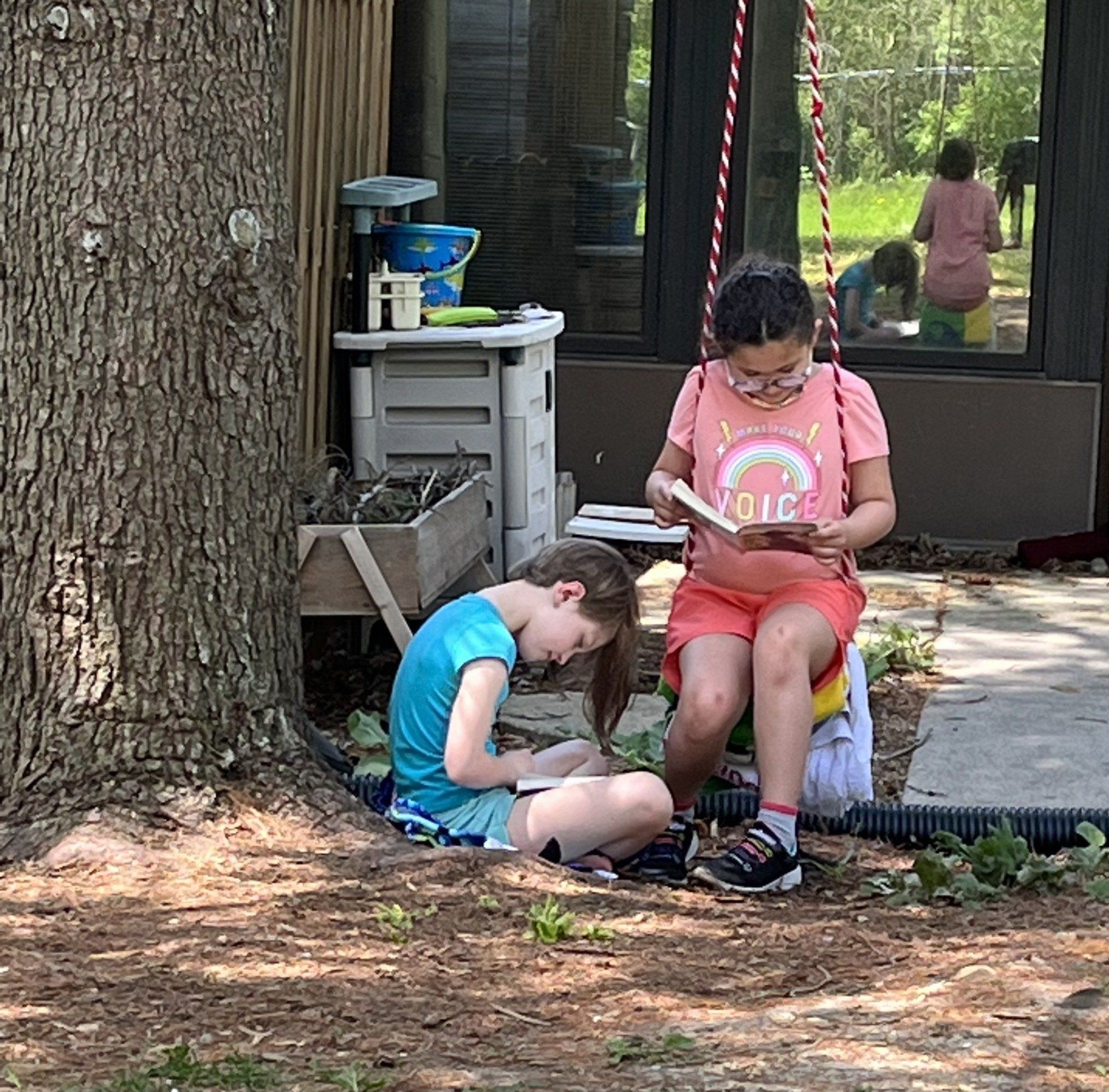 Montessori children reading outdoors