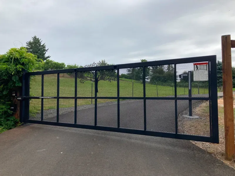 A black gate is sitting on the side of a road.