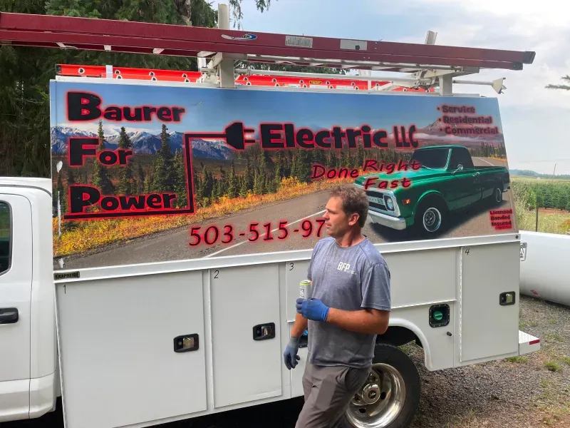 A man is standing in front of a bauer electric truck