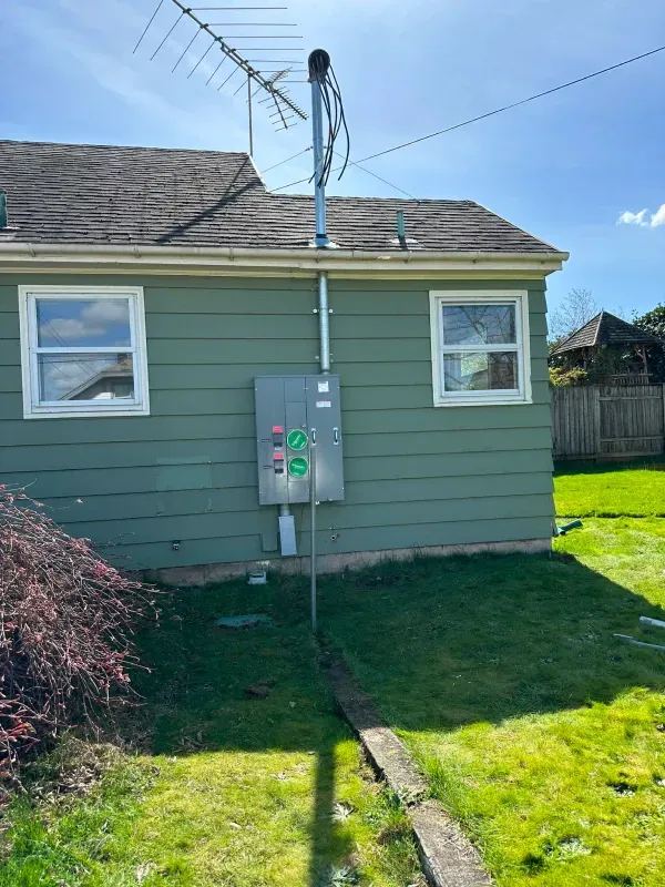 A green house with a satellite dish on the roof.