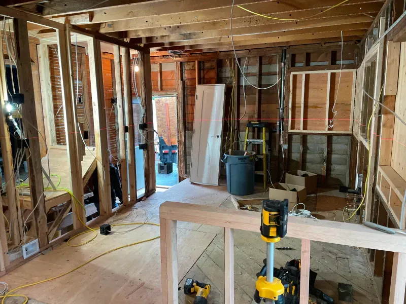 A room under construction with a ladder and a laser level.