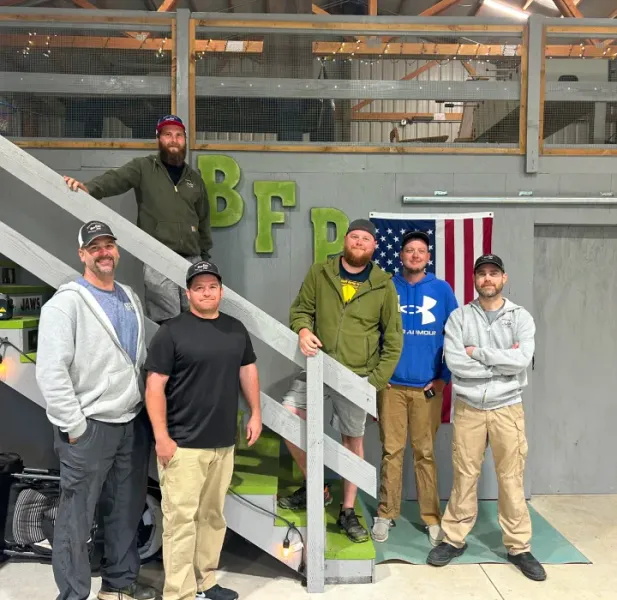 A group of men standing in front of a sign that says bfp