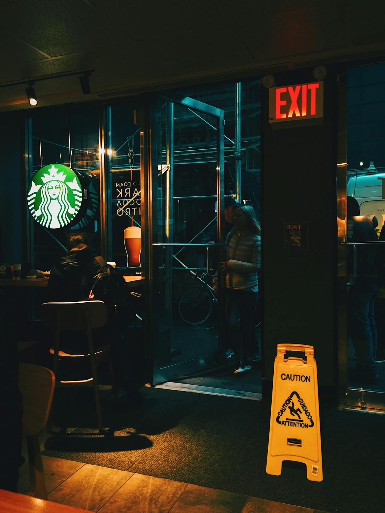 A starbucks restaurant with a caution sign in front of it