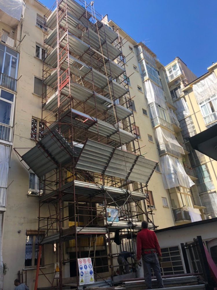 Un uomo è in piedi davanti a un edificio con un'impalcatura.