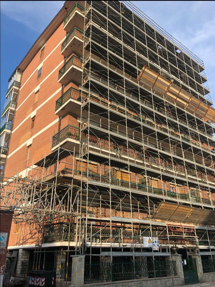 Si sta costruendo un grande edificio in mattoni circondato da impalcature.