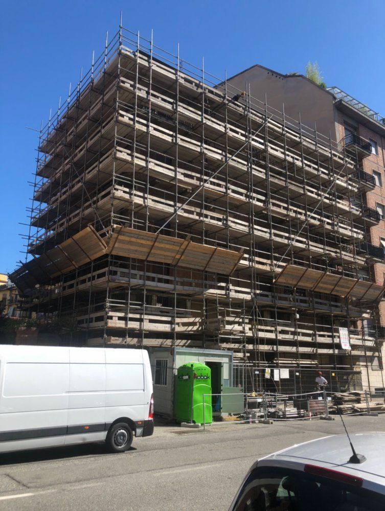 Un furgone bianco è parcheggiato davanti a un edificio in costruzione.