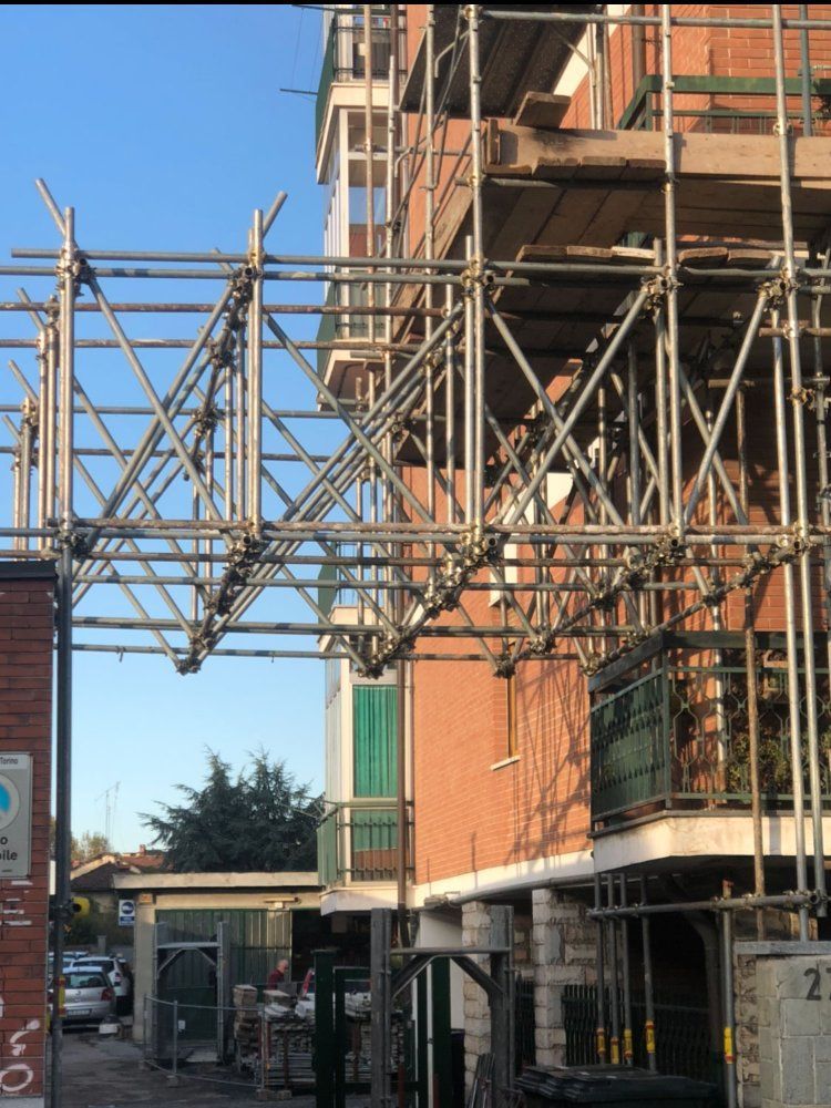 Un edificio in mattoni con impalcature sul lato