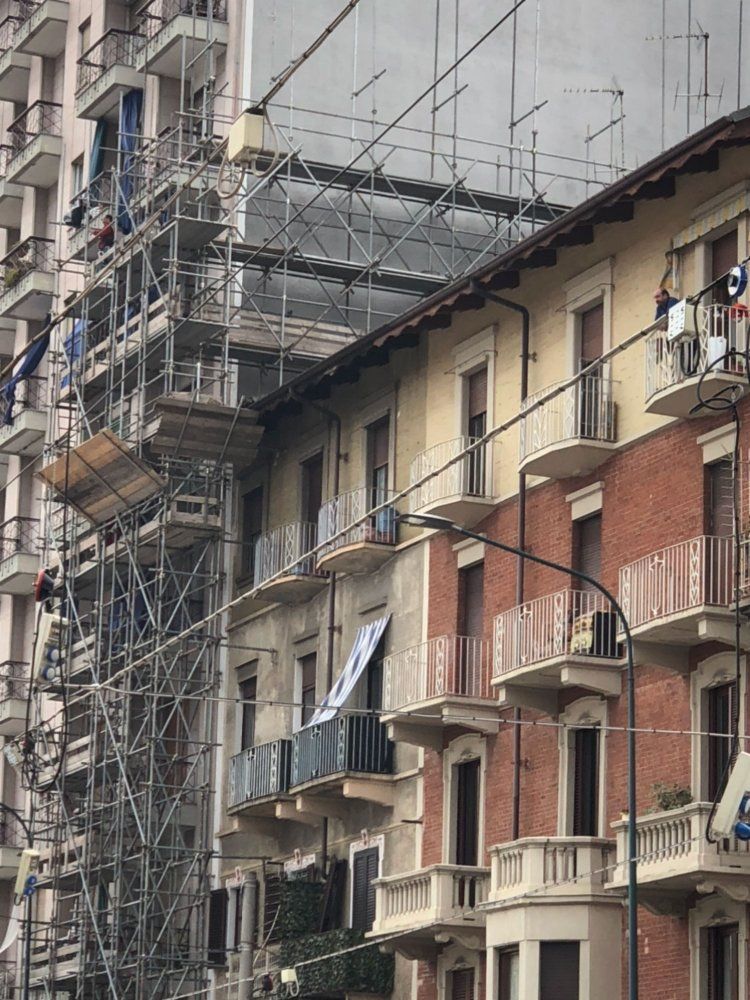 Un edificio con impalcature sui lati e balconi.