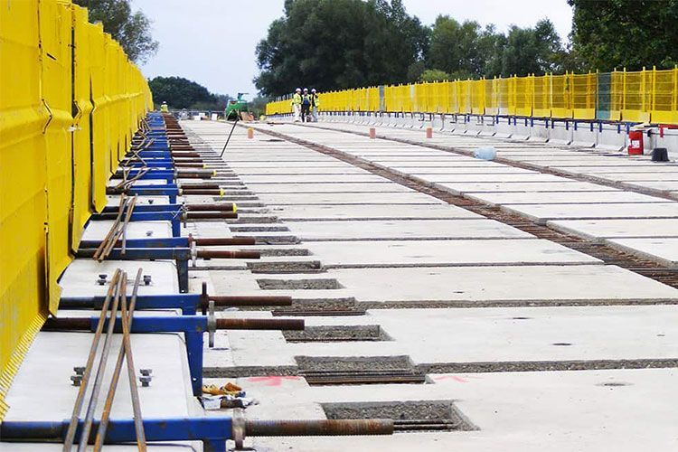 Un cantiere con una recinzione gialla sullo sfondo