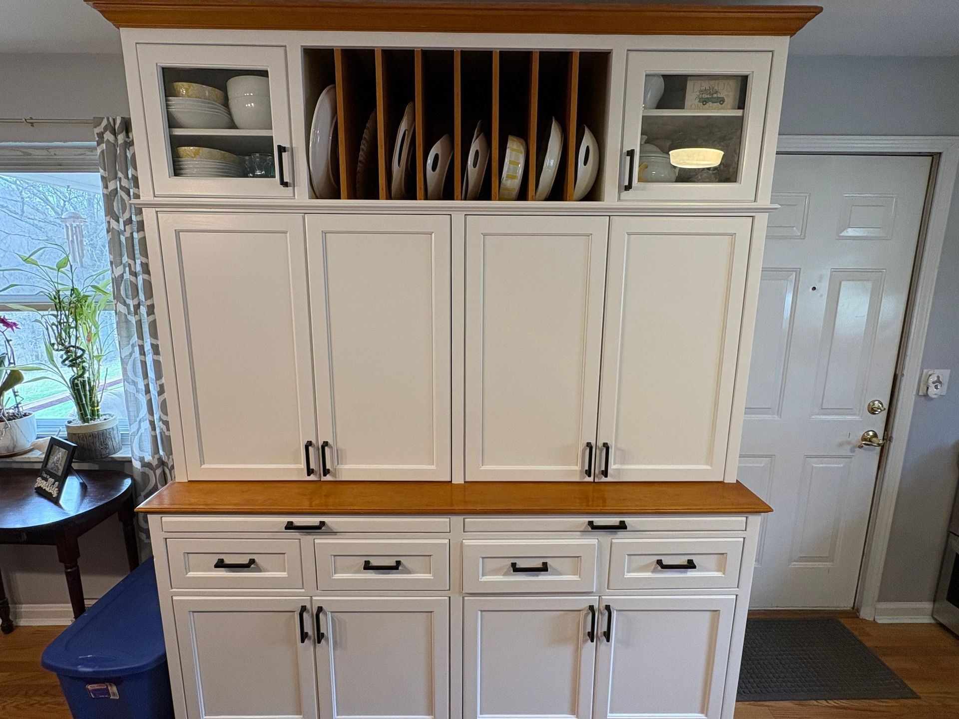White and wood kitchen hutch with cabinets, drawers, and plate storage.