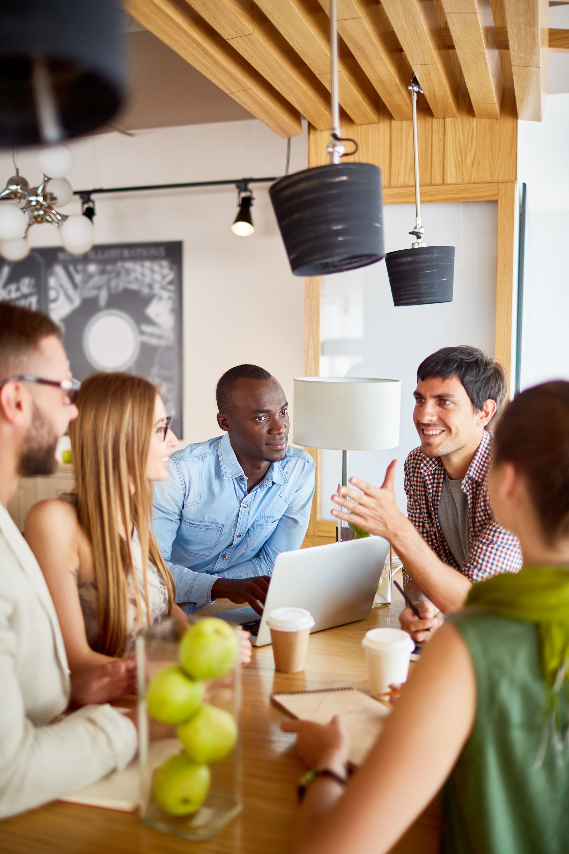 A group of people are sitting around a table having a meeting.