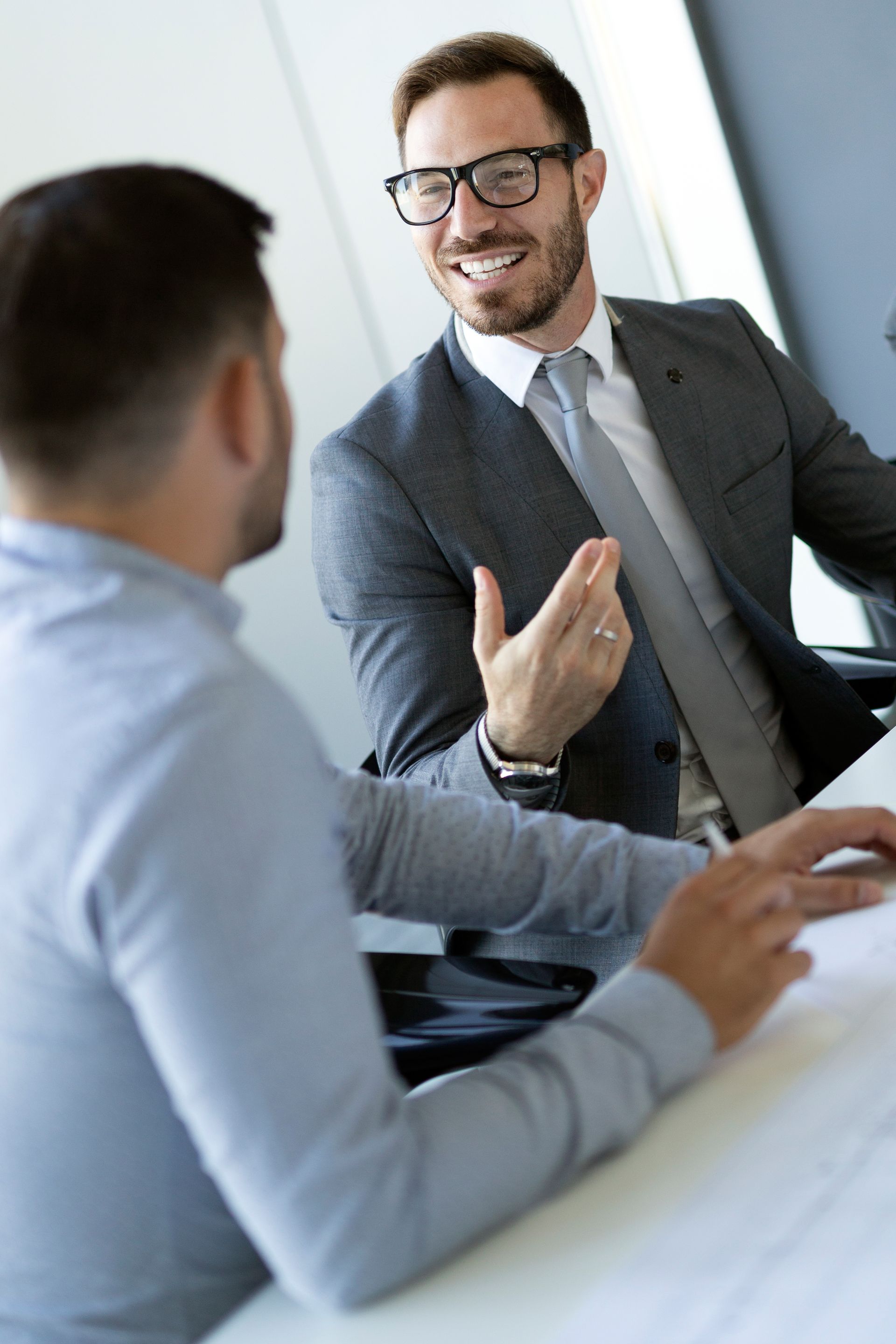Two men are sitting at a table having a conversation.