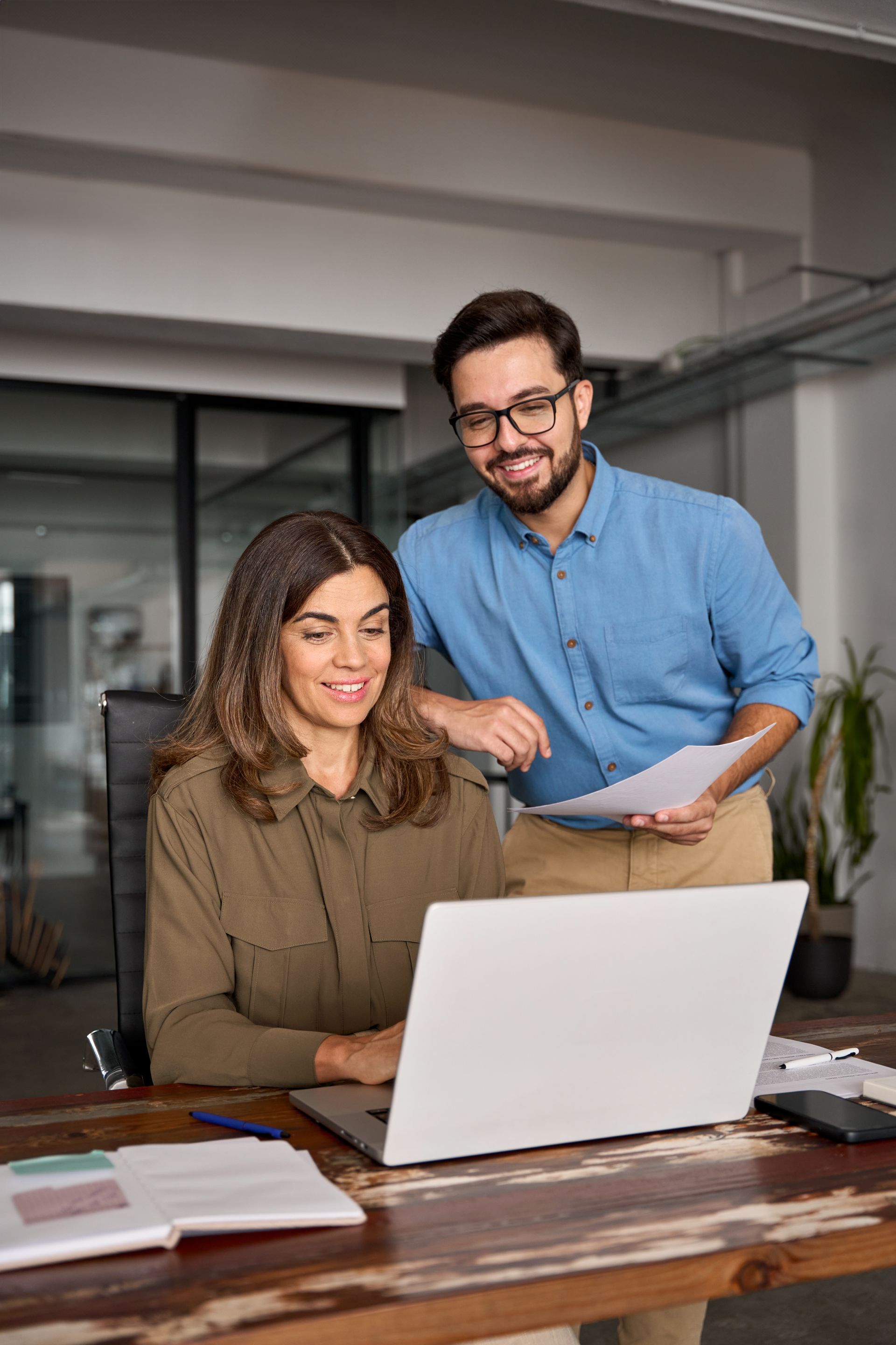 A man and a woman are looking at a laptop computer.