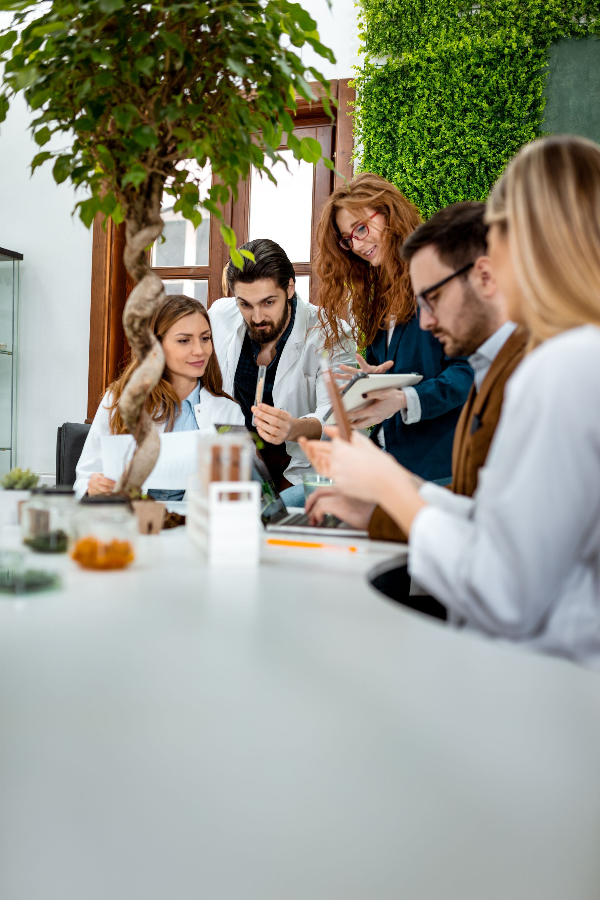 A group of people are sitting around a table having a meeting.