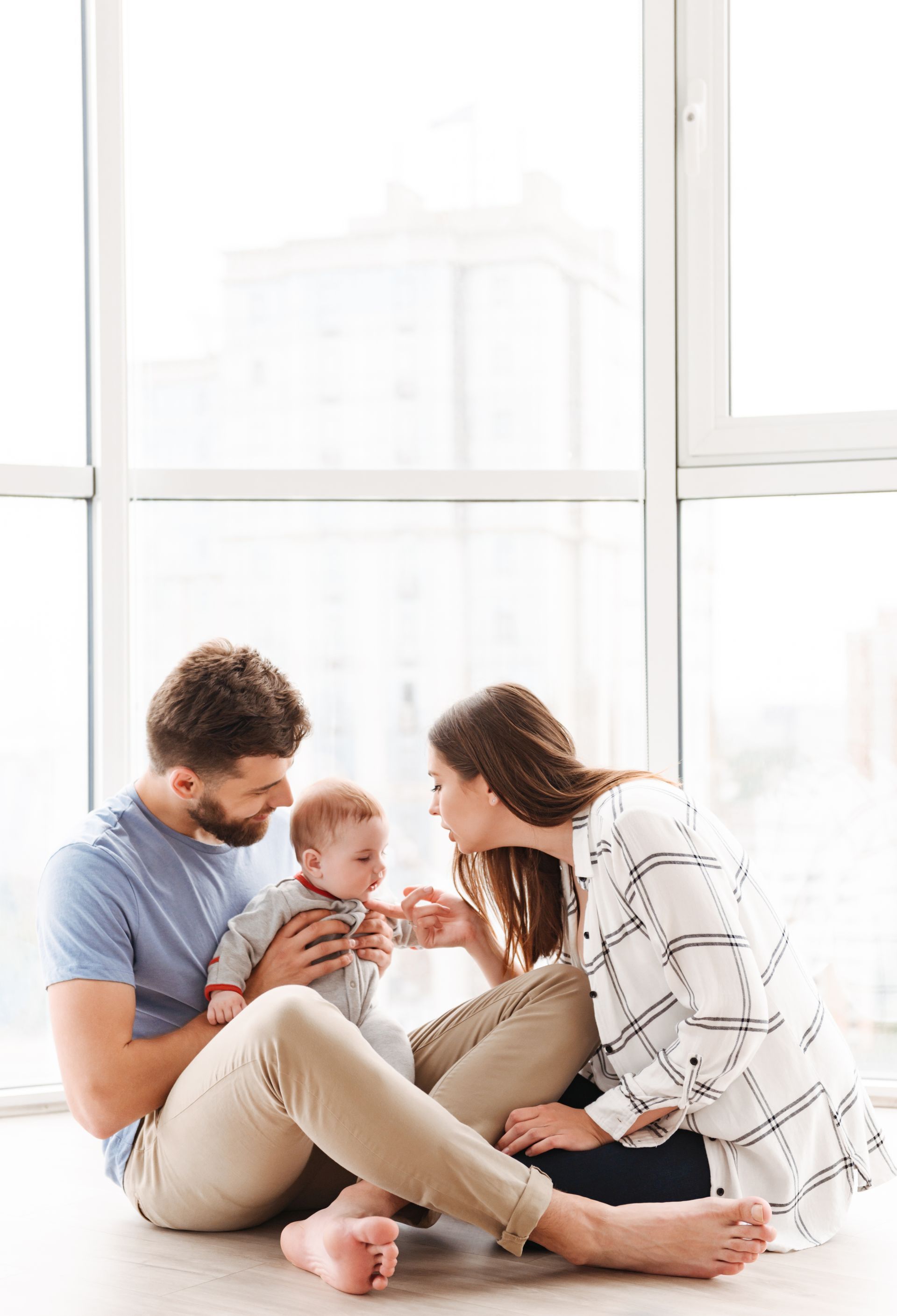 A man and a woman are sitting on the floor with a baby.