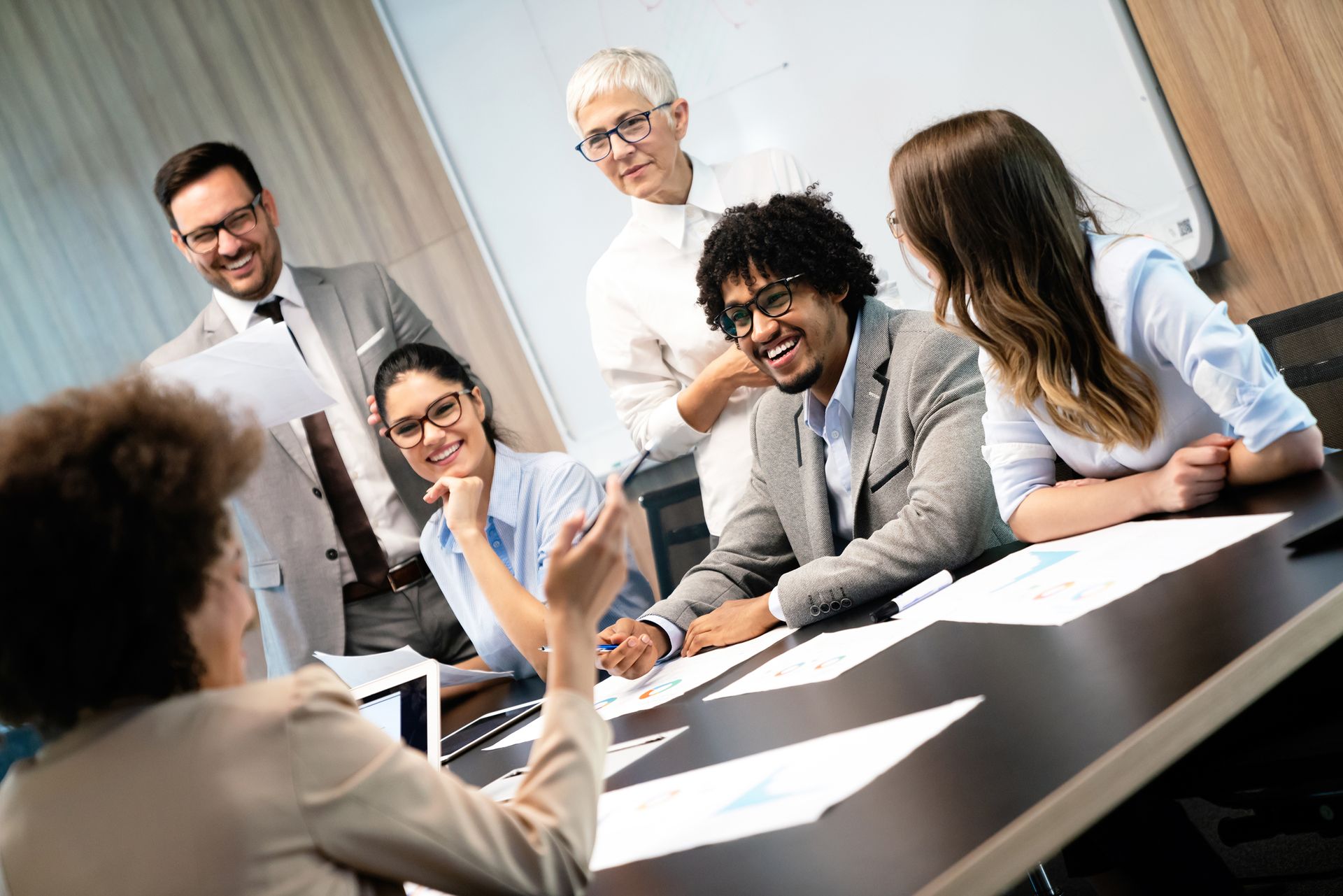A group of people are sitting around a table having a meeting.