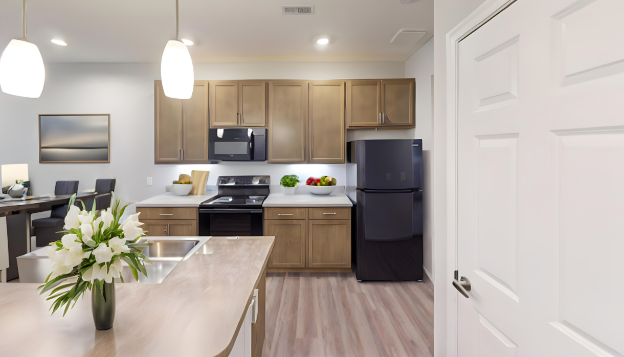 A kitchen with wooden cabinets , a black refrigerator , a stove , and a sink.