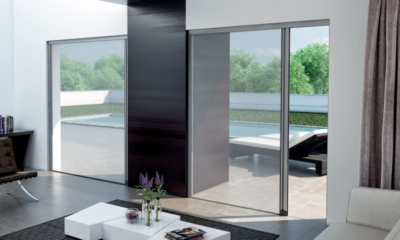 Un soggiorno con una porta scorrevole in vetro che conduce a un patio.