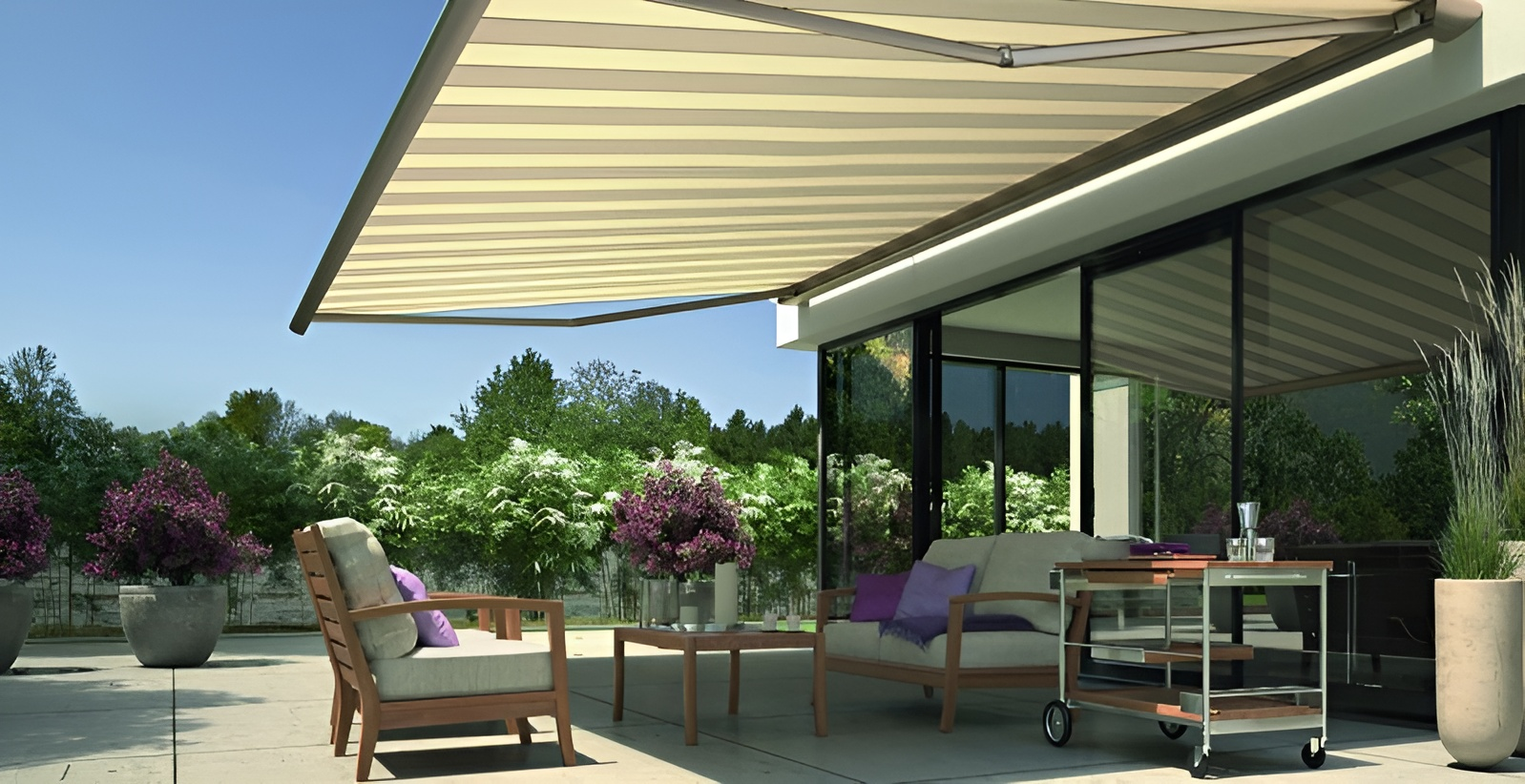 Un patio con un divano, sedie e un tavolo sotto una tenda da sole.