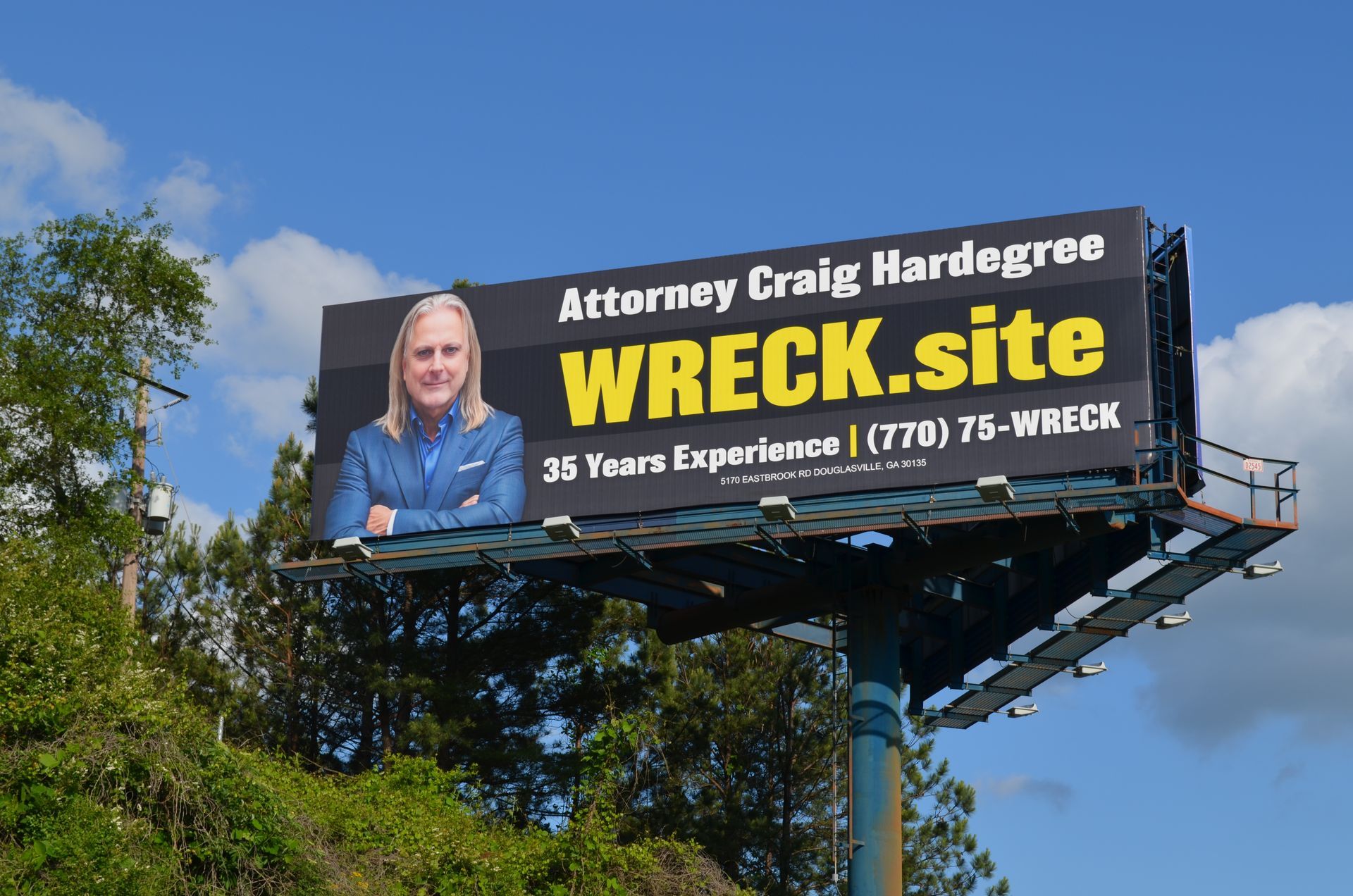 A billboard against a blue sky featuring Attorney Craig Hardegree, his website 