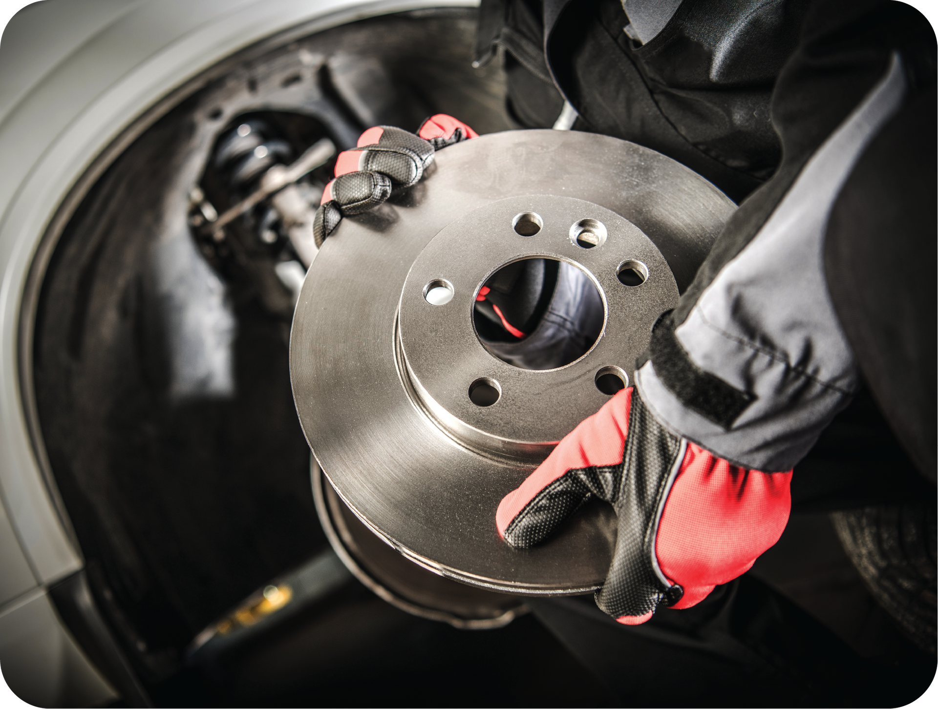 A person is fixing a brake disc on a car.