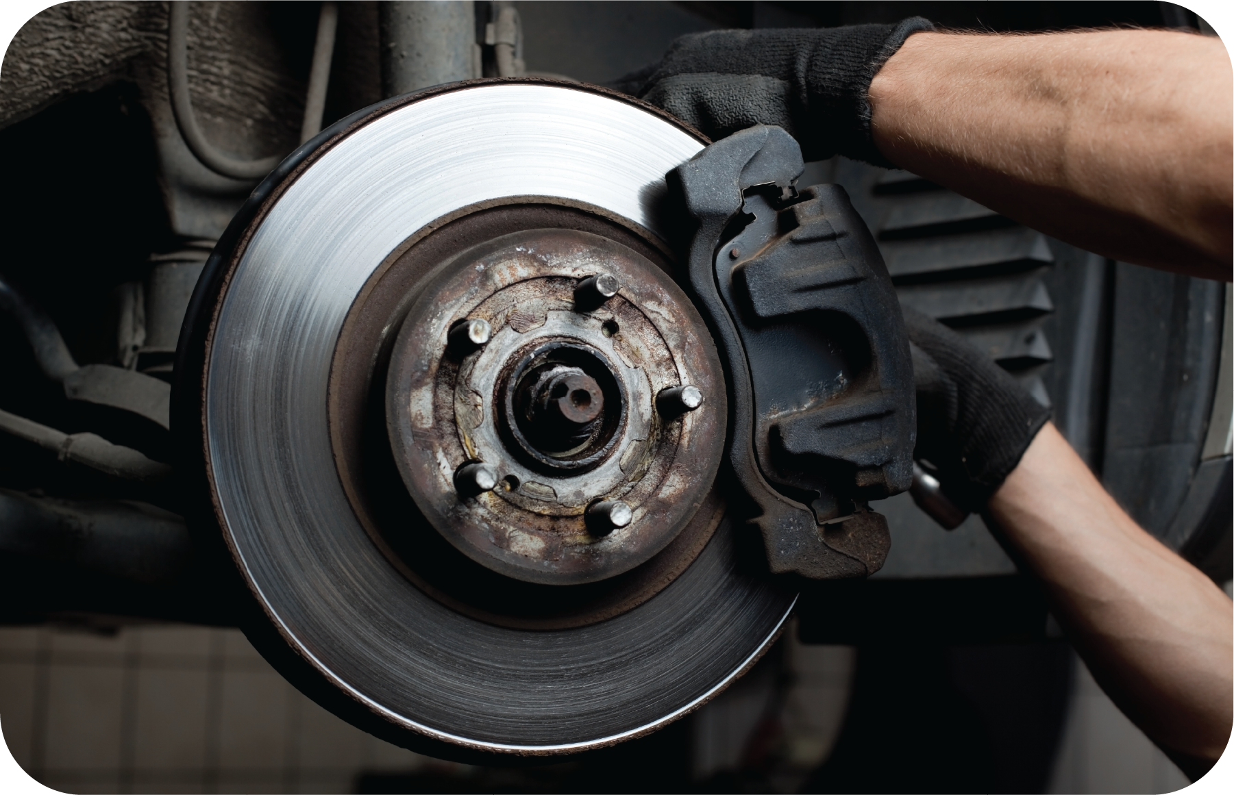 A person is fixing a brake pad on a car.