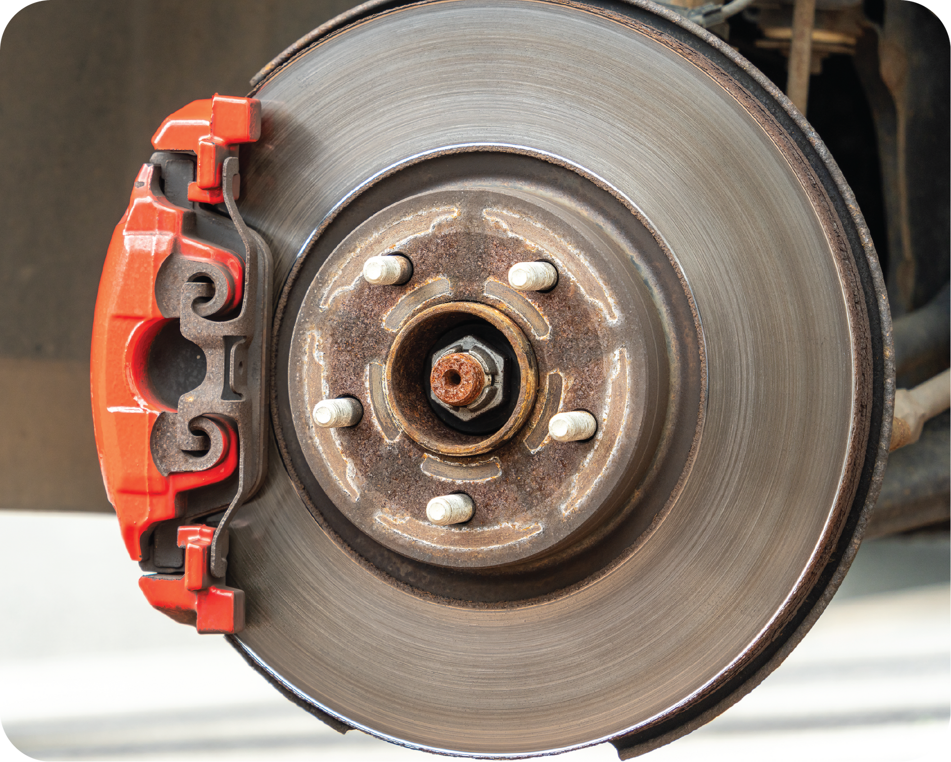 A close up of a brake disc with a red brake caliper