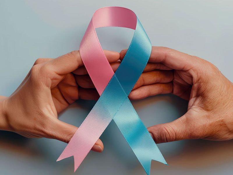 Hands in the shape of a heart with cancer ribbon symbolizing healing