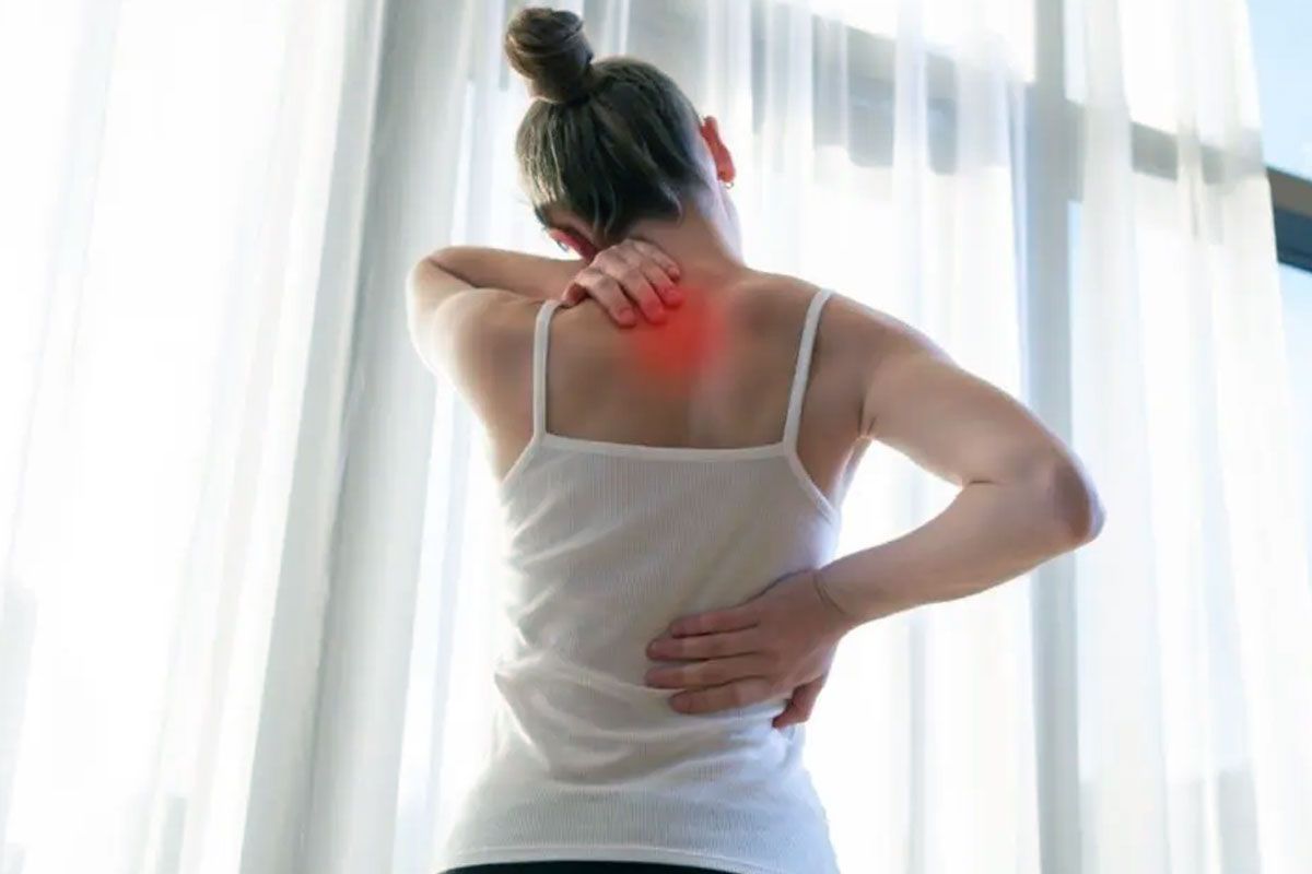Woman struggling with chronic pain between her shoulder blades