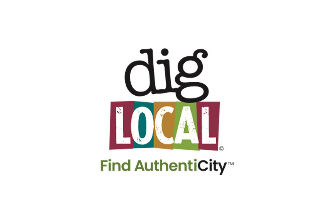 A table with plates of food, drinks, and two people reaching for a phone.