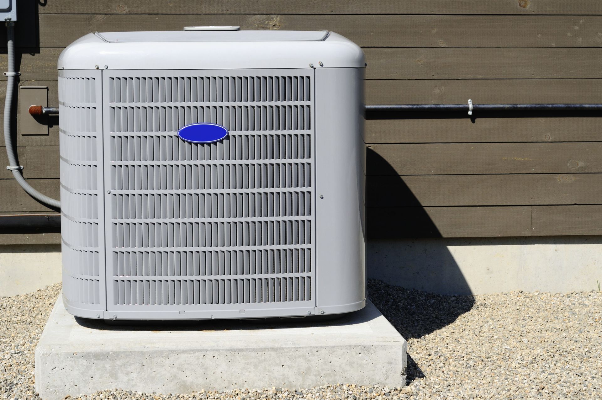 A carrier air conditioner is sitting outside of a building