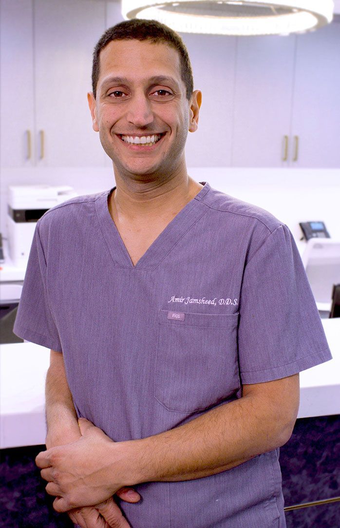 Dr. Jamsheed in a purple scrub top is smiling for the camera.