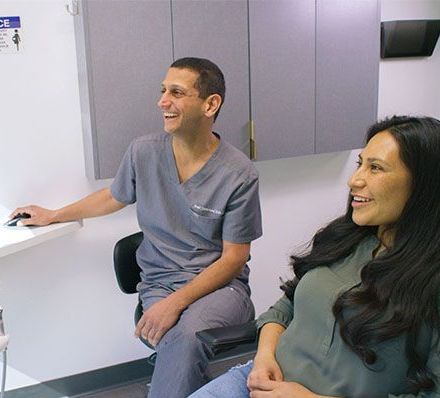 A man and a woman are sitting next to each other in a dental office.