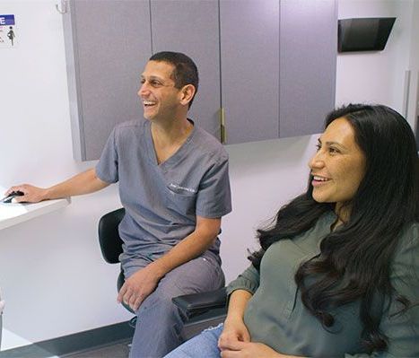 A man and a woman are sitting next to each other in a dental office.