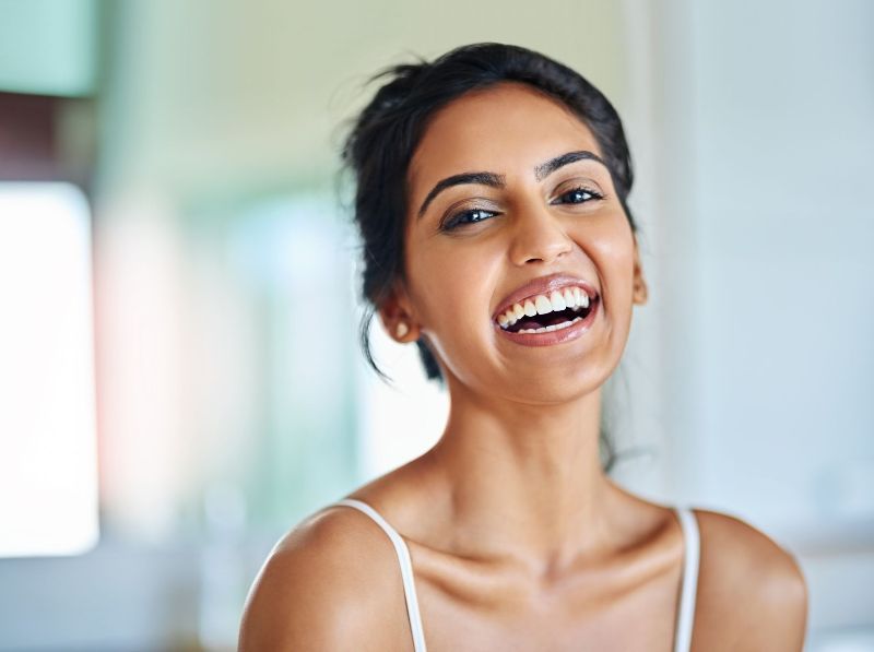 A close up of a woman laughing with her mouth open.