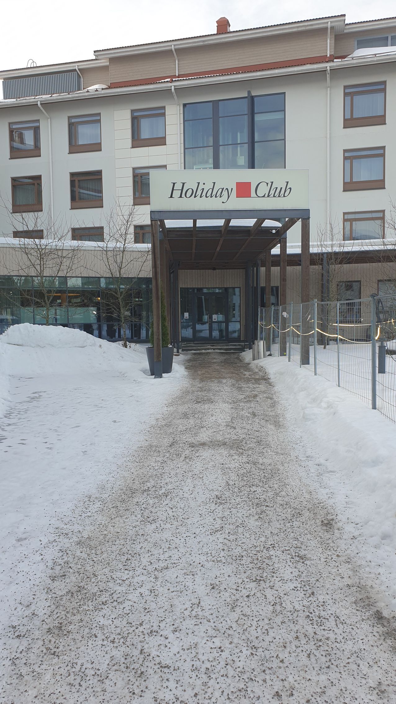 The entrance to a hotel is covered in snow.