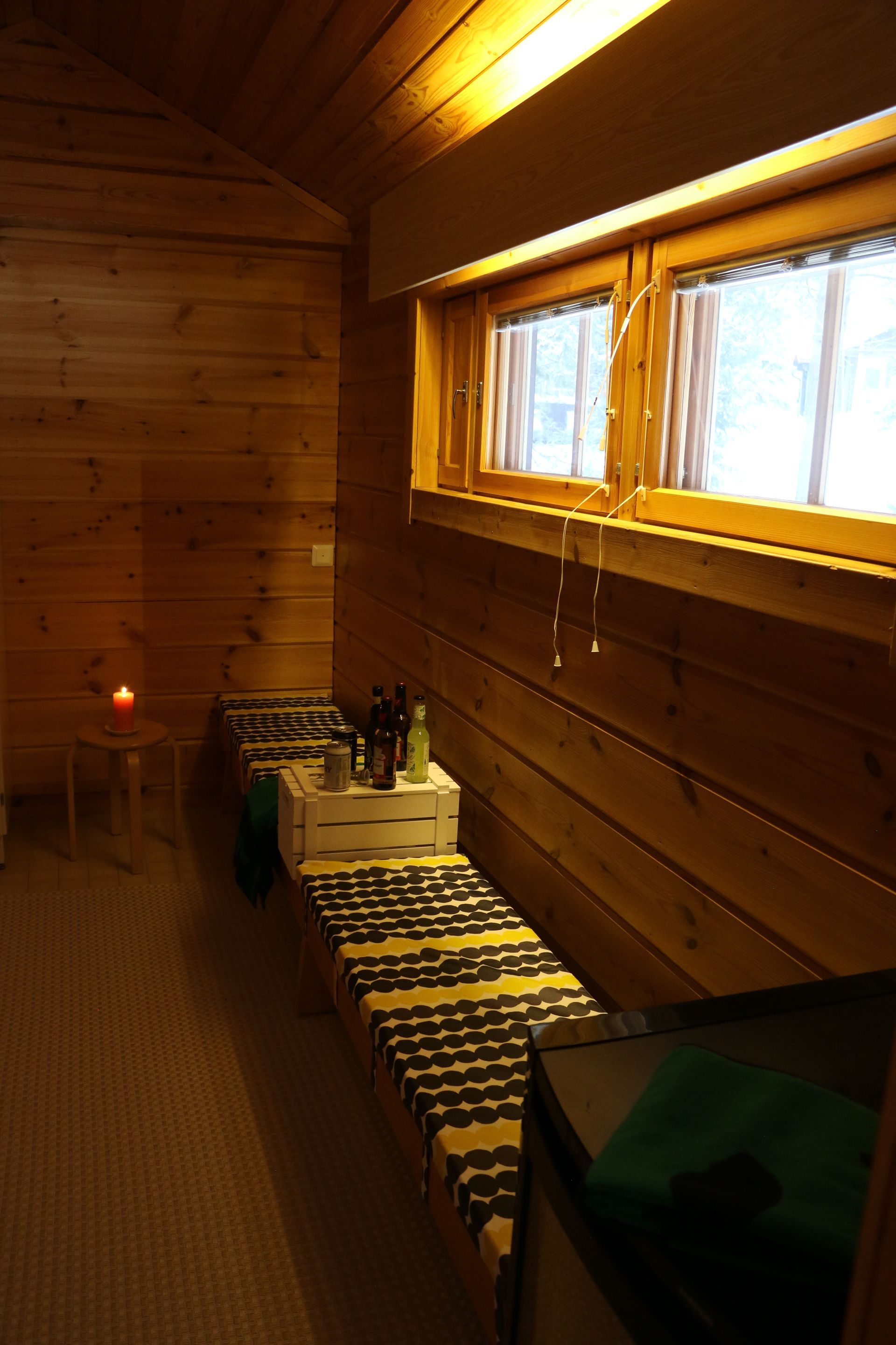 A wooden room with two beds and a window