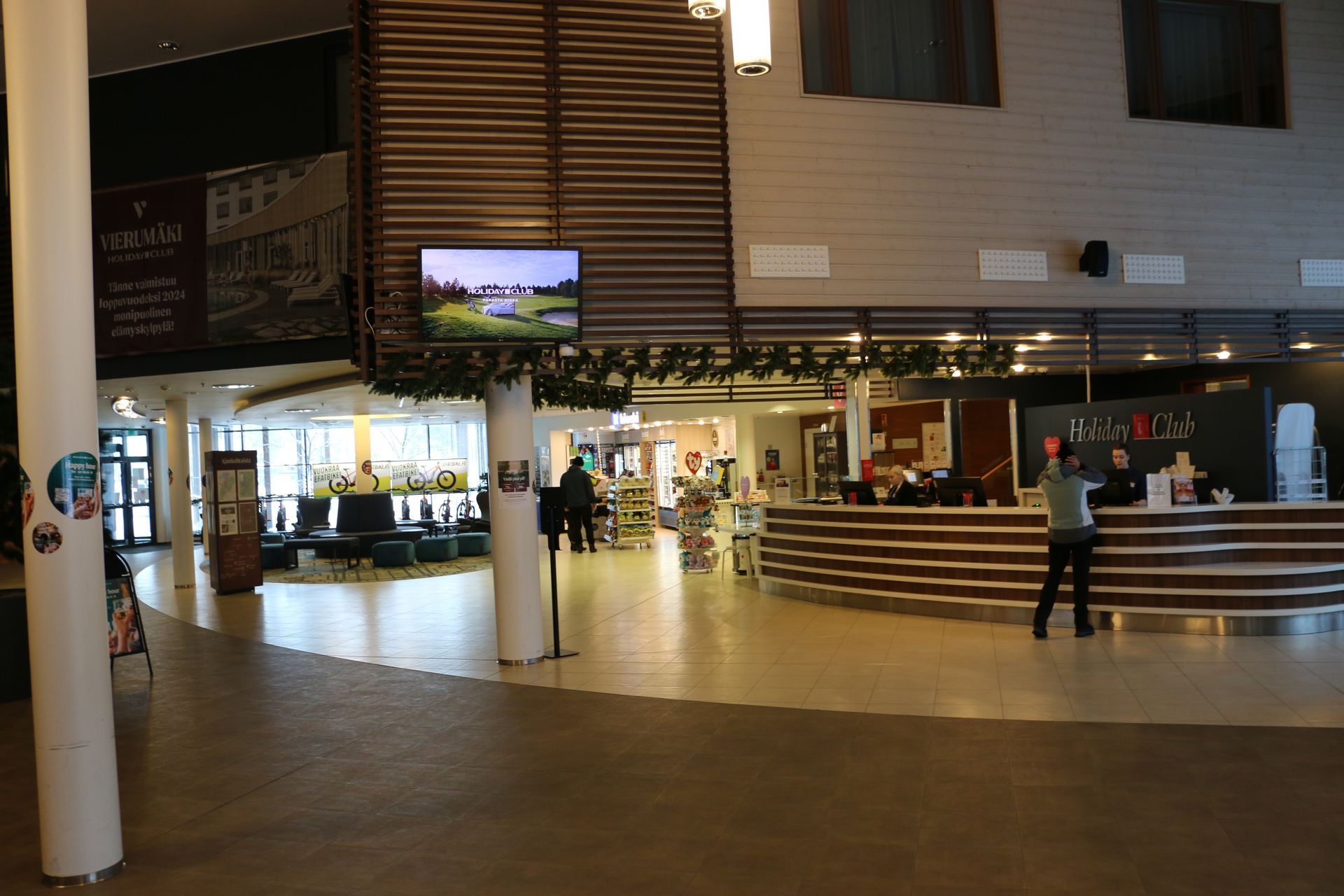 A lobby of a hotel with a large screen on the wall.