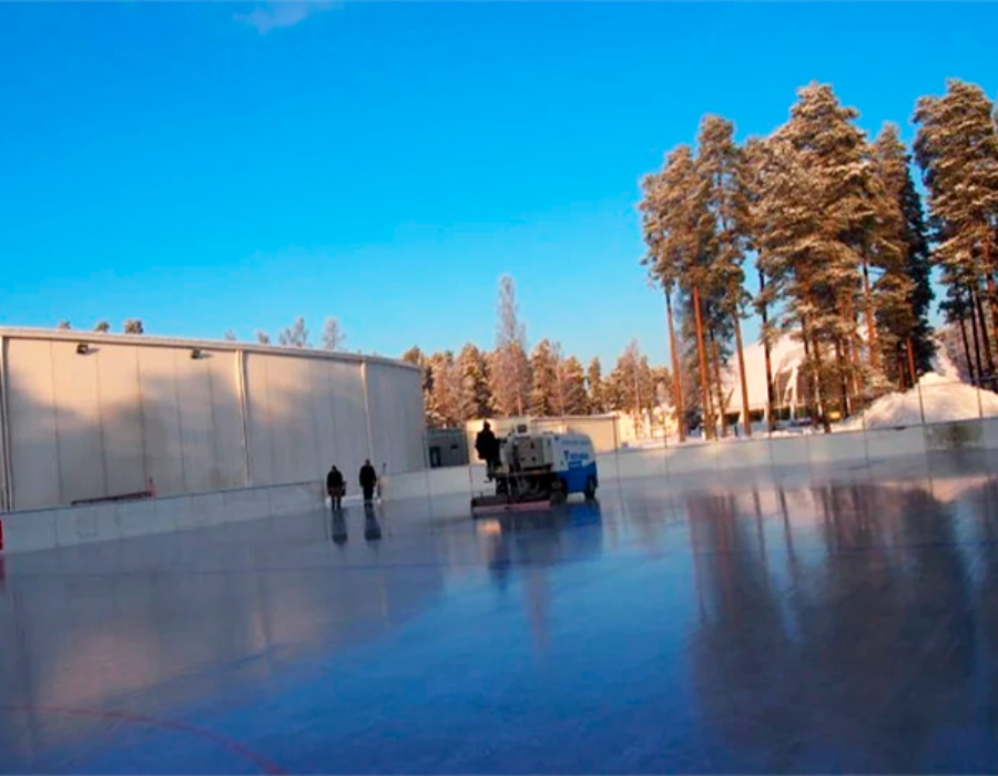 A group of people are standing on a ice rink.