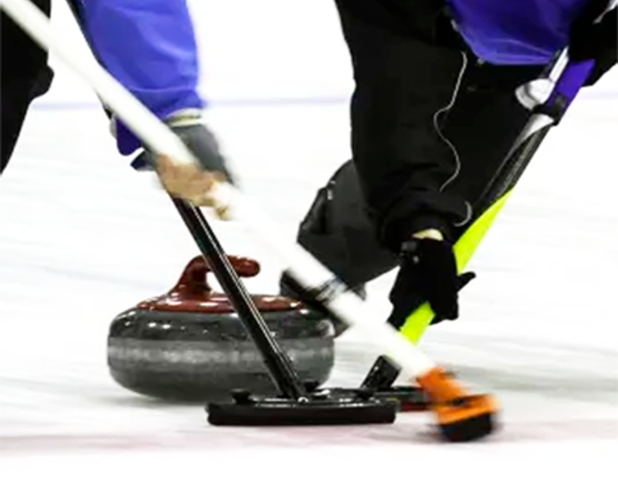 A group of people are playing curling on a rink