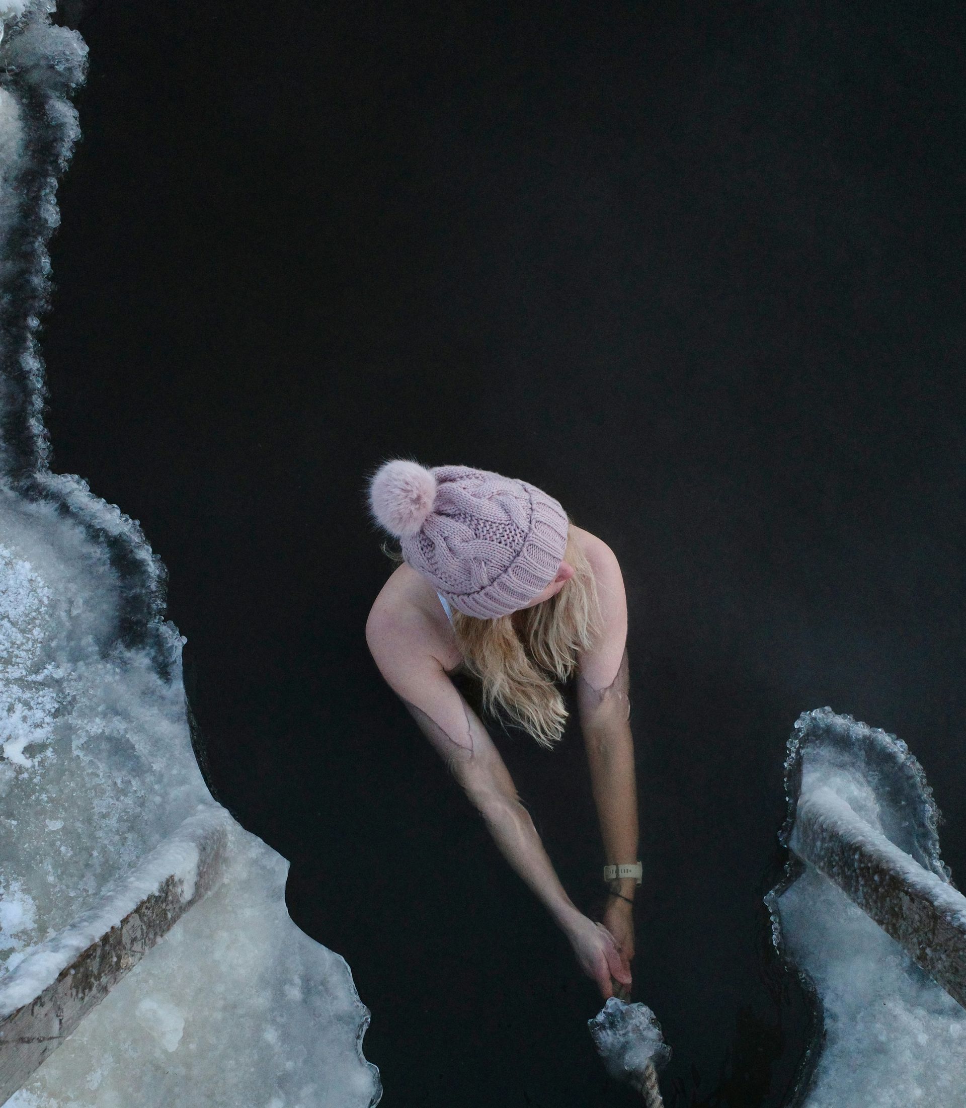 A woman in a pink hat is standing in the water