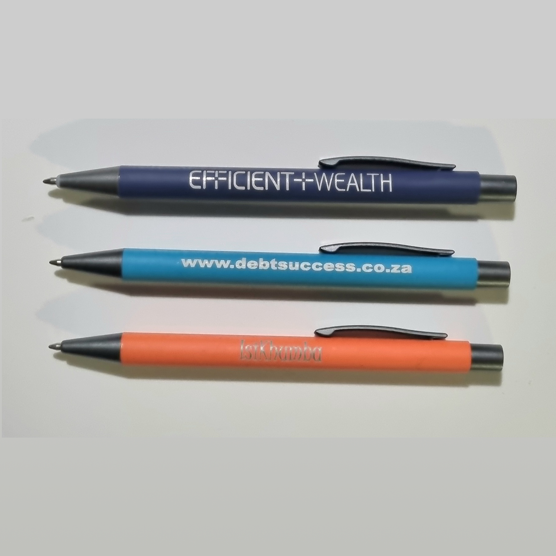 Three pens with the words efficiently wealth written on them