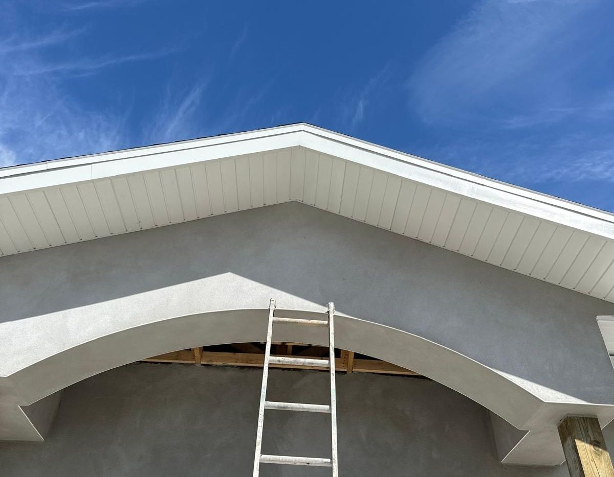 A ladder is sitting under the roof of a house under construction.