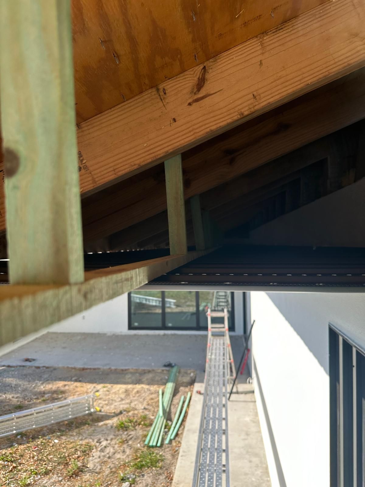 A ladder is hanging from the ceiling of a building under construction.